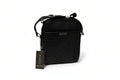 Black Gucci bag with a tag on a white surface